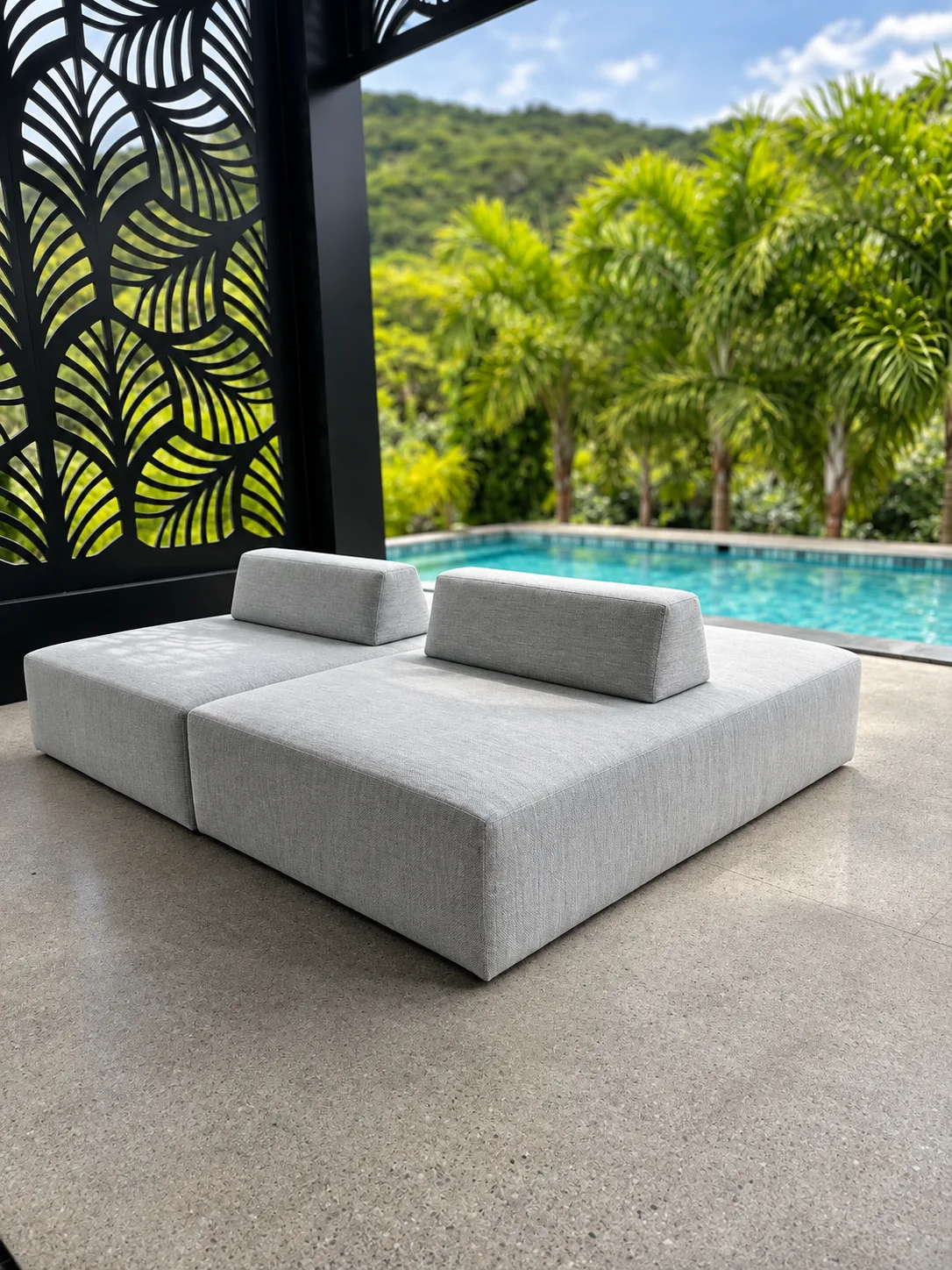 Estofado modular cinza com dois apoios junto à piscina